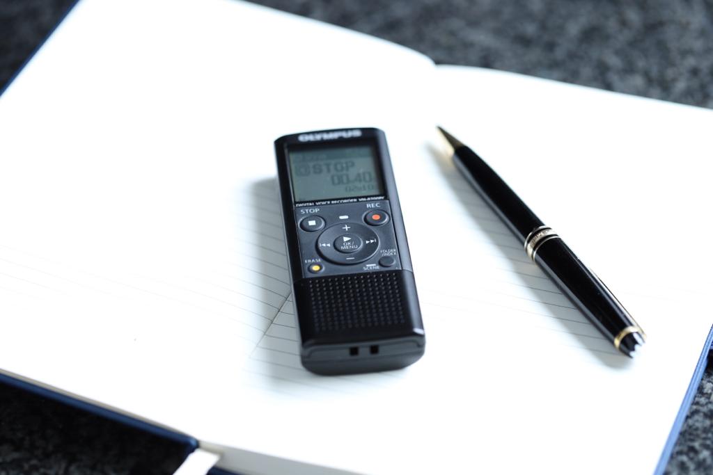 voice recorder and pen on notebook